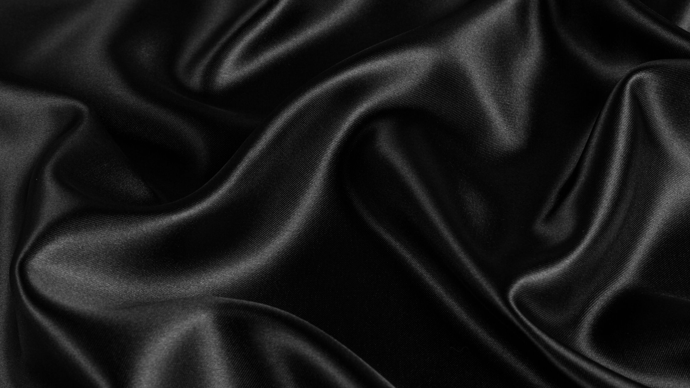 Close-up of black satin fabric with folds